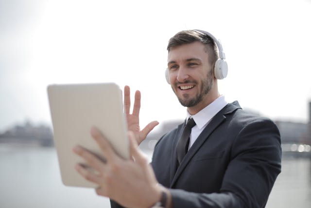 man using AI while on a tablet and wearing headphones remotely